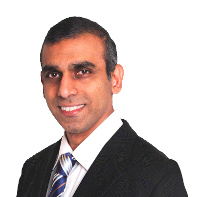 Dr Edwin Figuiera wearing a suit with a blue and white tie and smiling