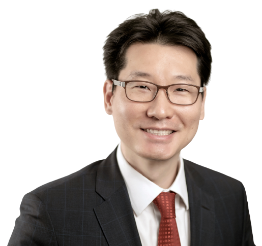 Dr John Chang wearing a suit and red tie smiling